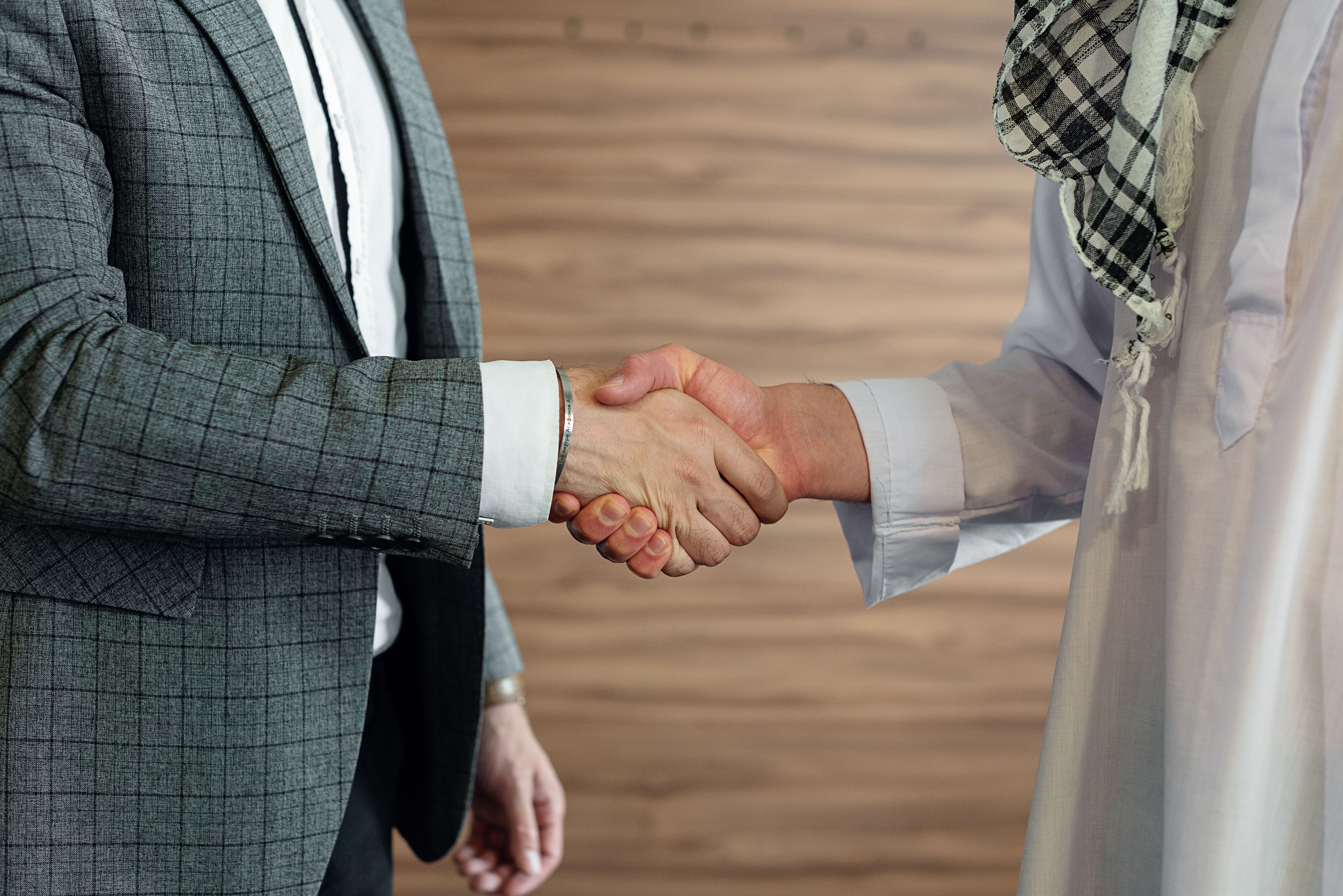Close-up of two men in business attire shaking hands, symbolizing cooperation and partnership
