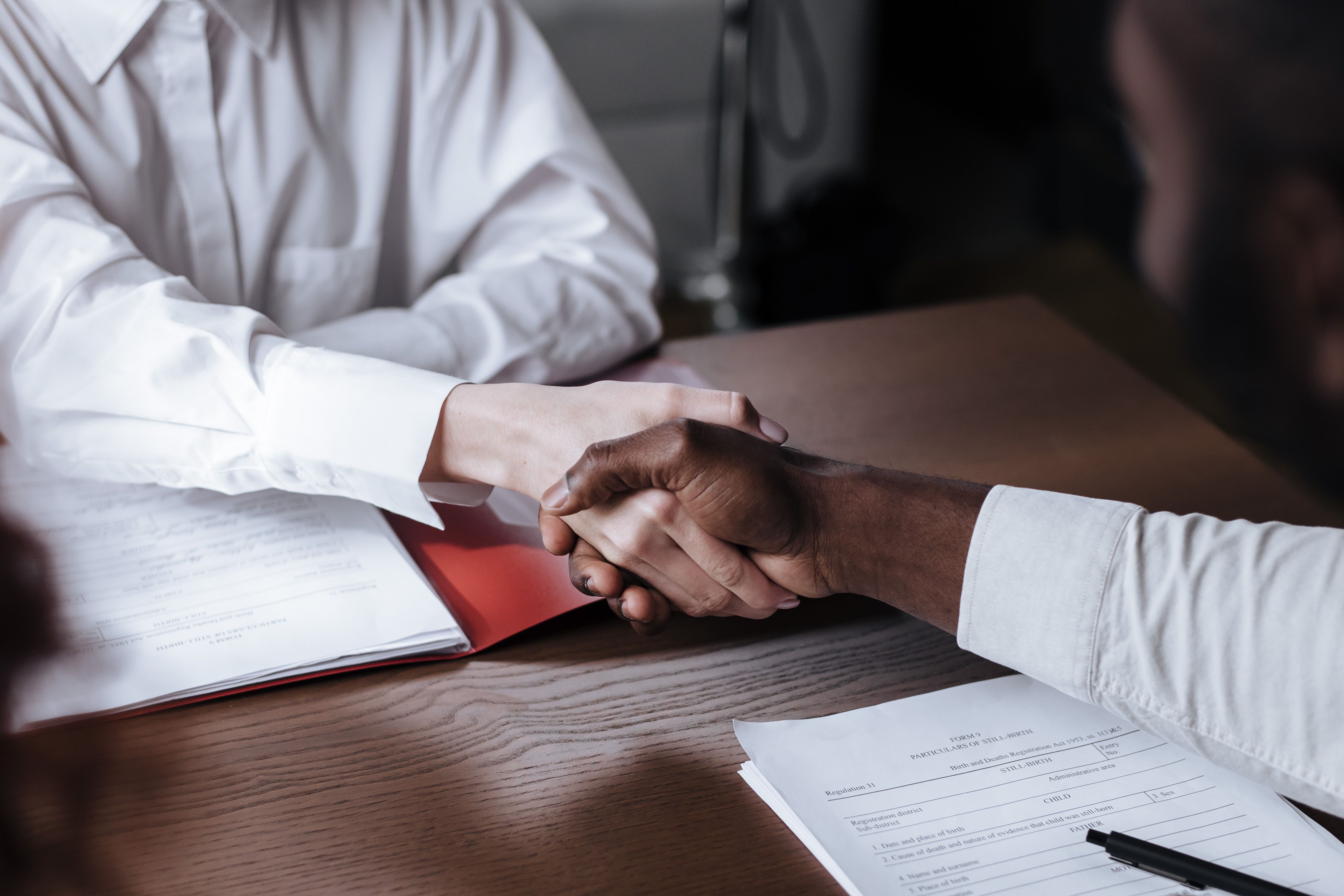 Close-up of a business handshake over documents, symbolizing cross-border agreement