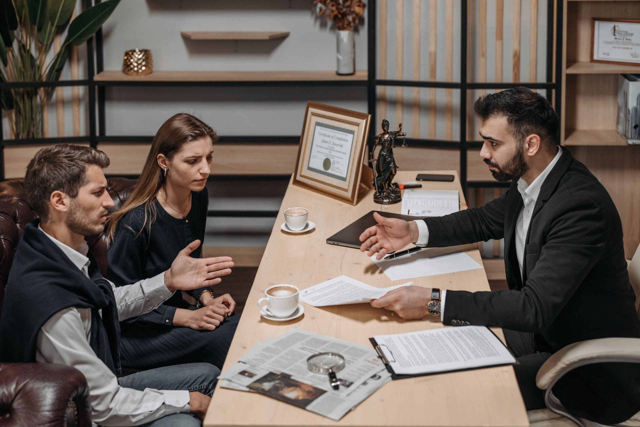 Lawyer consulting clients in an office with legal documents on the table