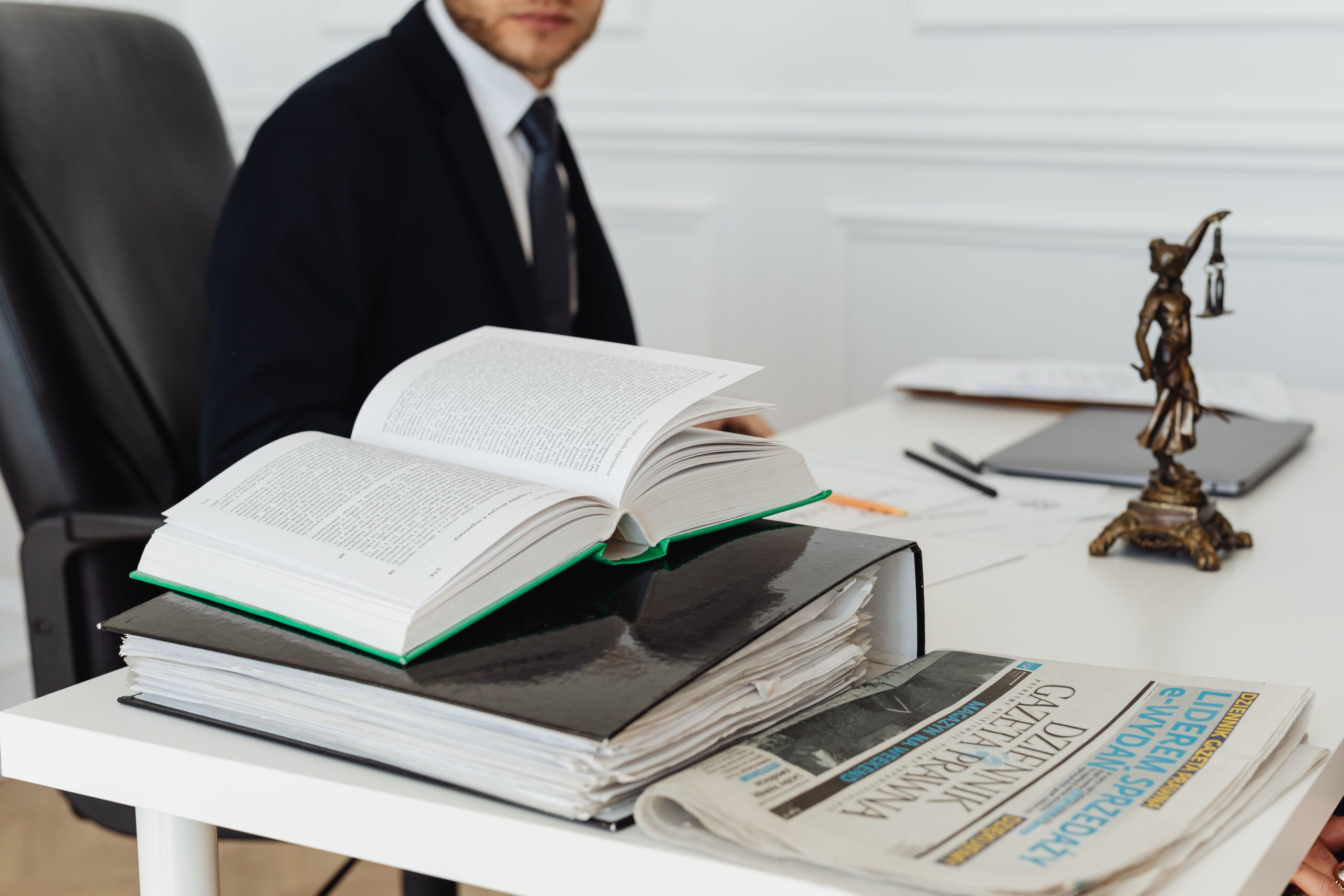 Lawyer sitting at a desk surrounded by legal books and documents, representing litigation and legal representation