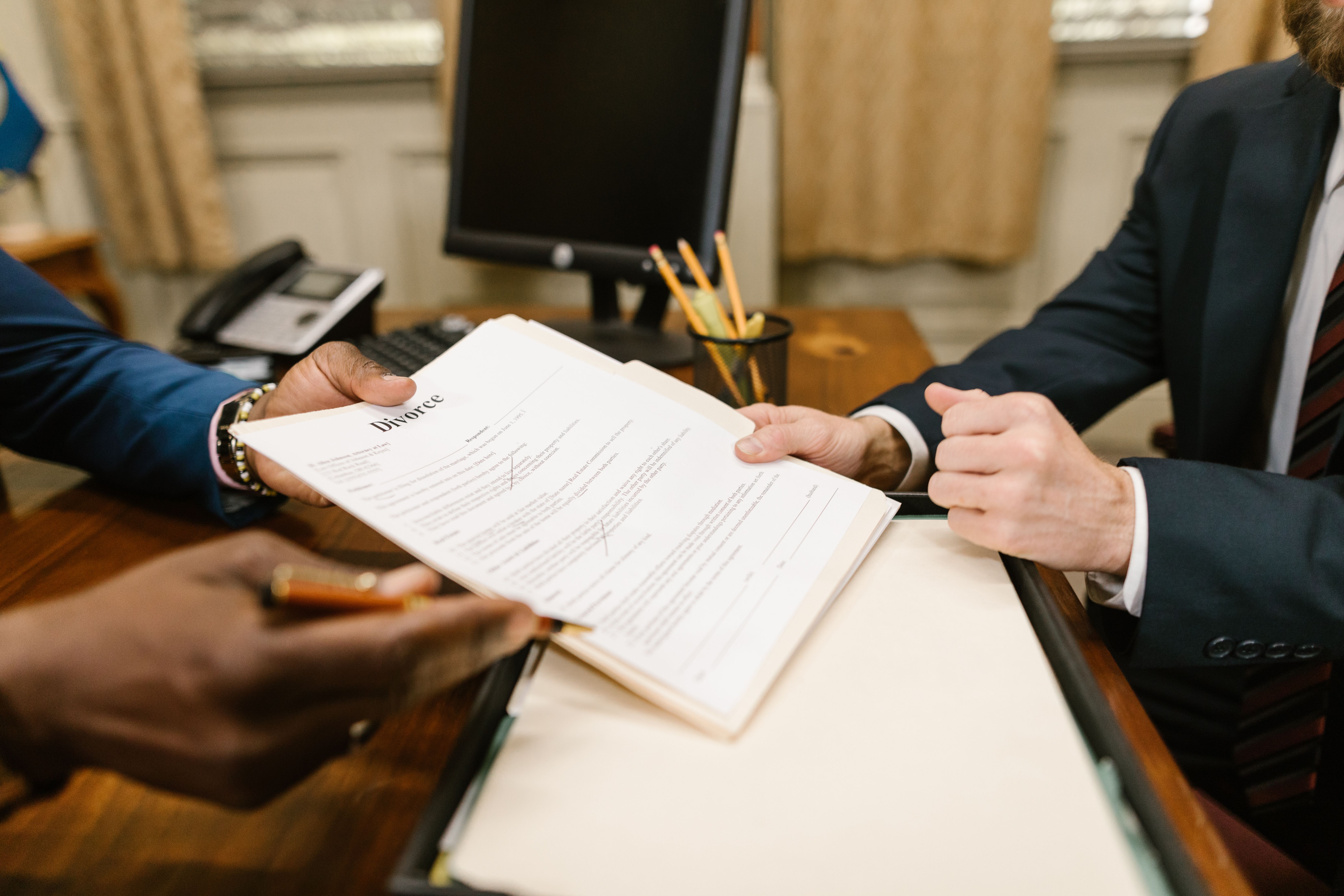 Hands exchanging legal documents during a law office case handover